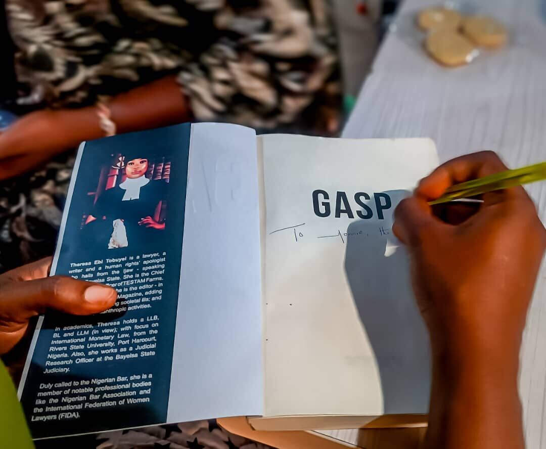 An author signing a copy of GASP