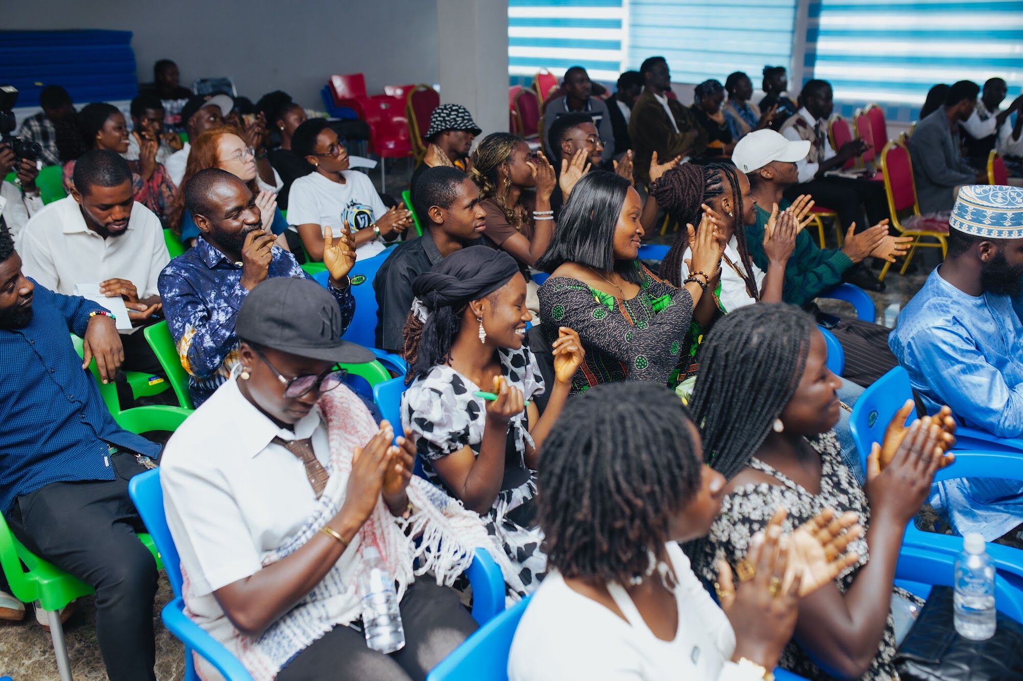 An audience cheering at a COAL Open Mic night